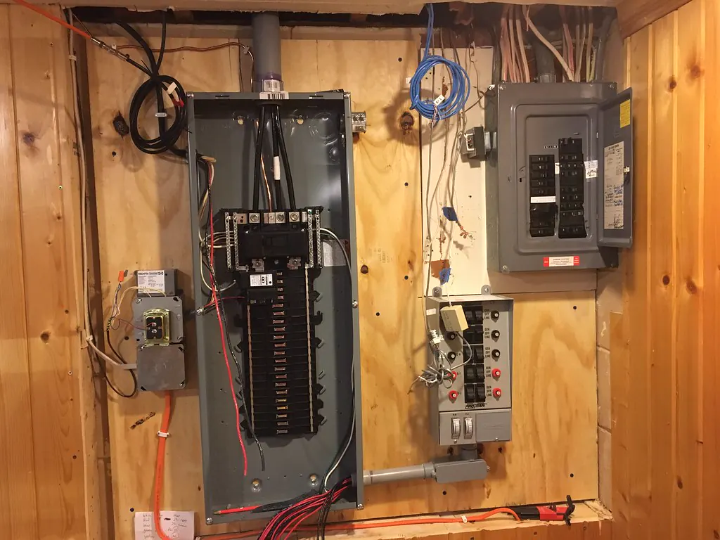 A new 200-amp breaker panel installed next to an older full 100-amp panel